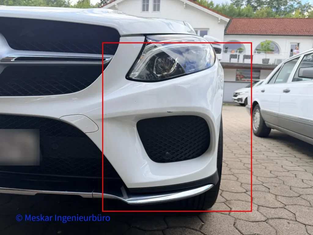 Weißer SUV mit leichtem Frontschaden am Stoßfänger, rot markiert