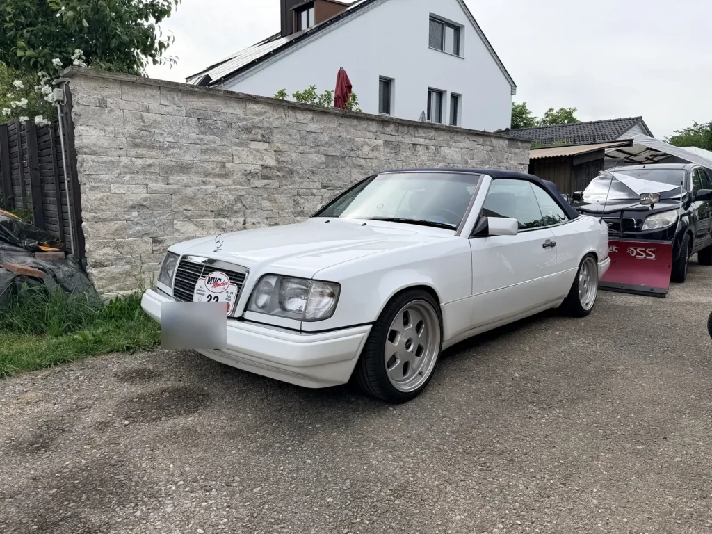 Weißes Mercedes-Cabrio vor einer Natursteinmauer, Wertgutachten in München